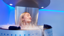 Load image into Gallery viewer, A customer inside a nitrogen based Cryotherapy chamber for weight loss, anti aging, and for less pain and inflammation.